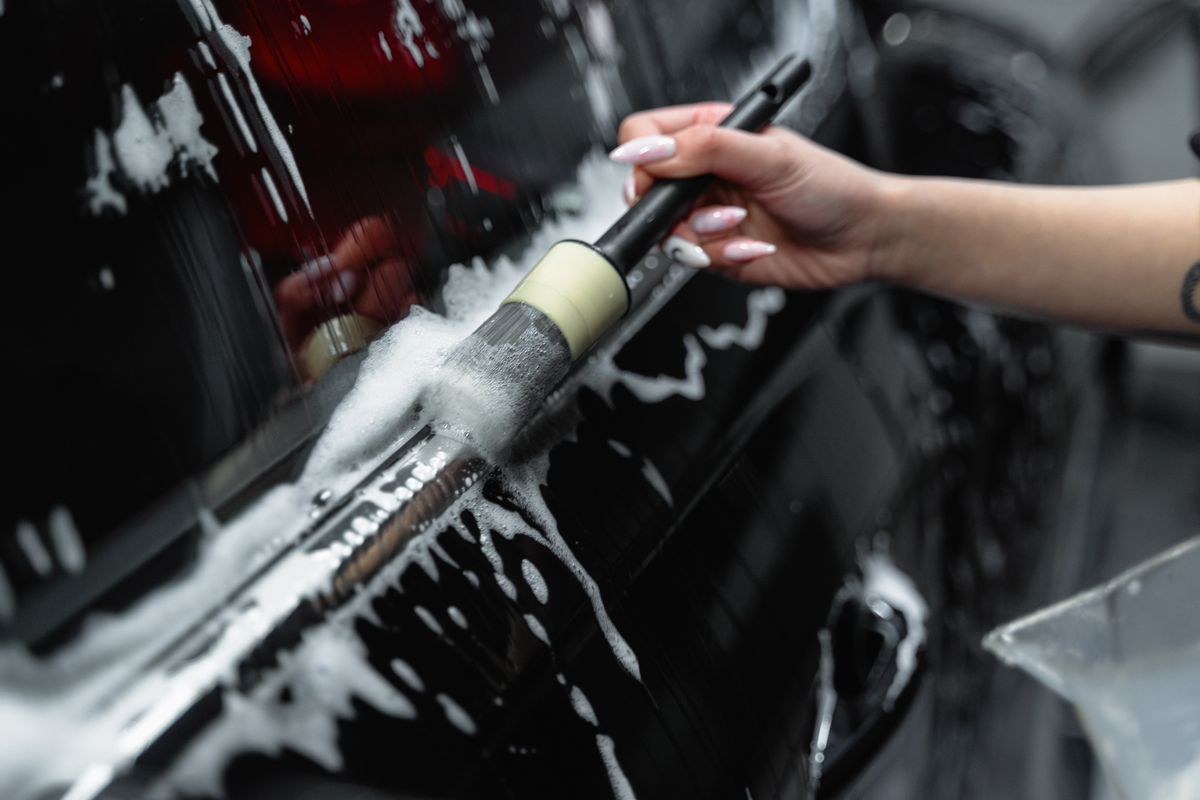 Close-up of a brush cleaning a glossy car surface