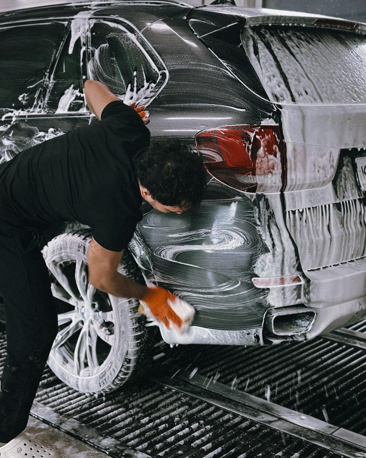 Professional washing a vehicle inside a premium car wash facility