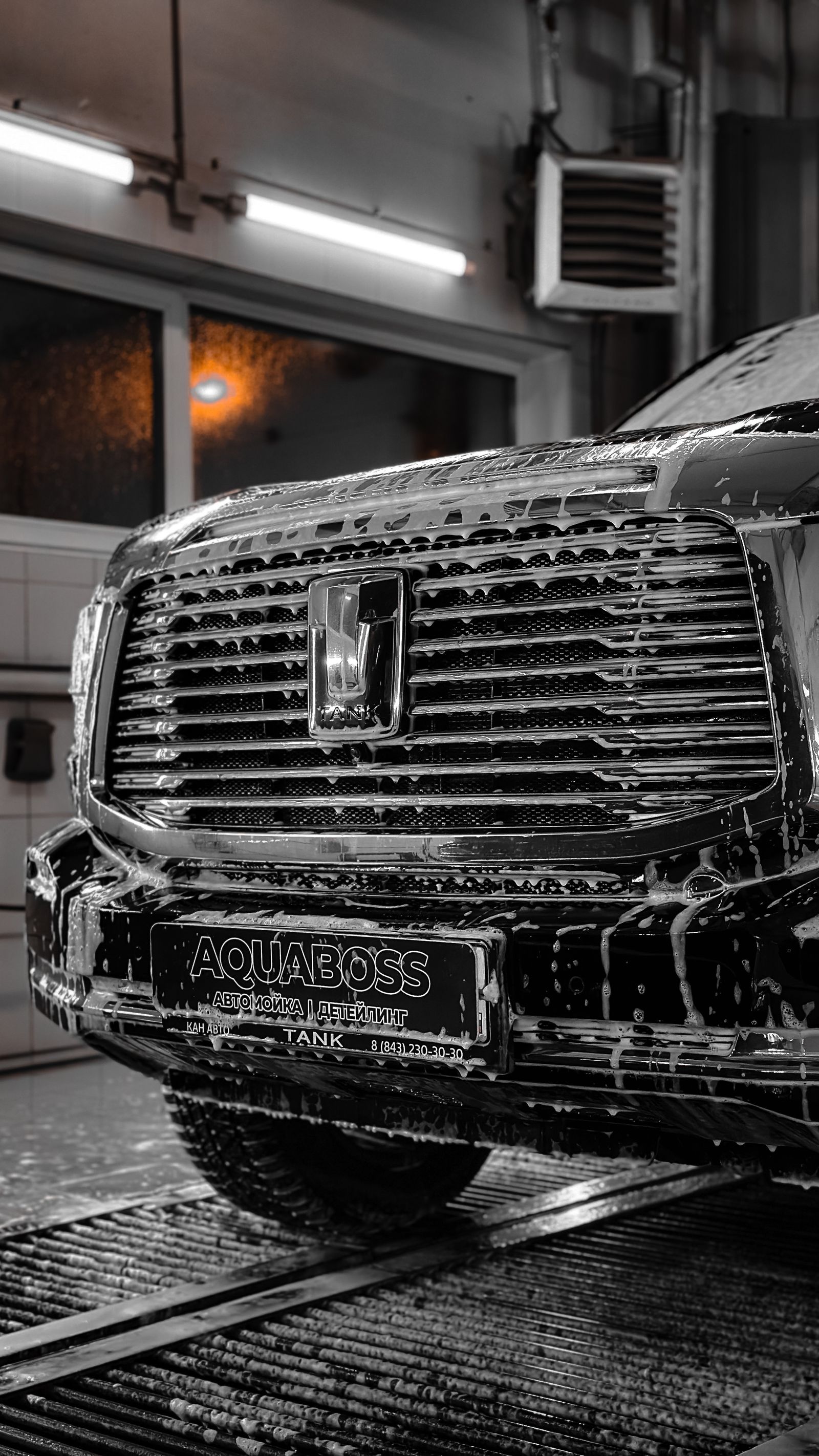 Luxury black car in a sleek indoor wash environment